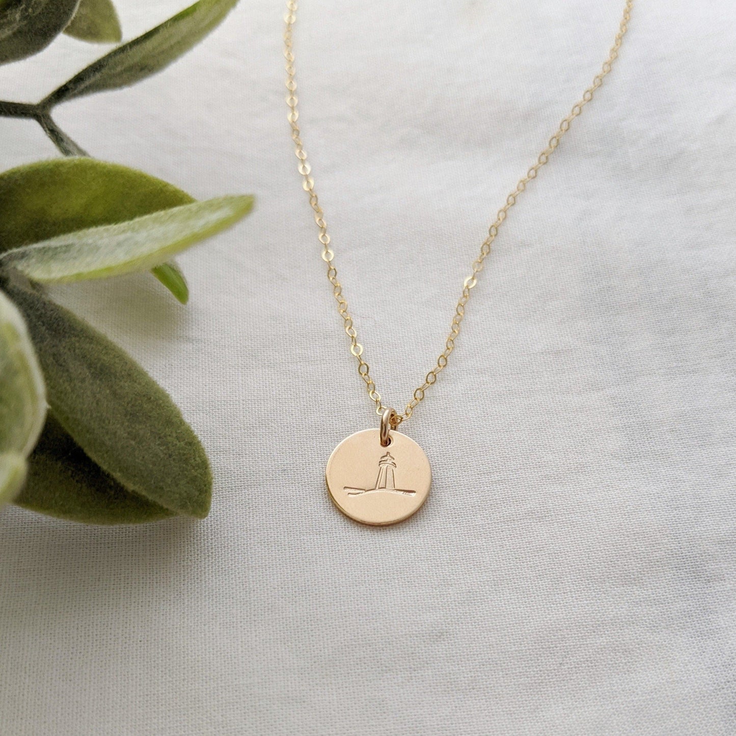 gold filled disc with lighthouse