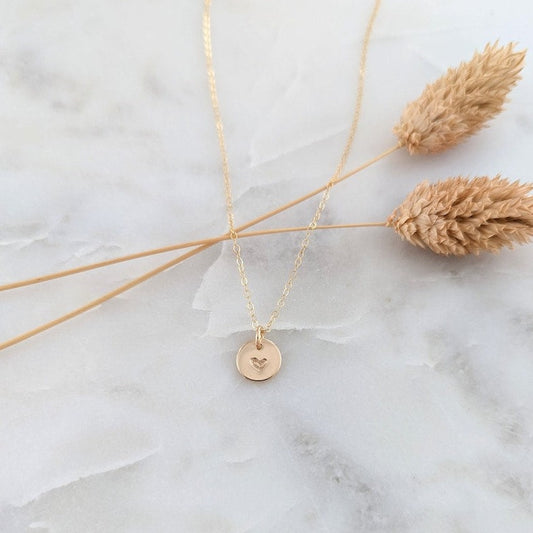 tiny gold disc with heart