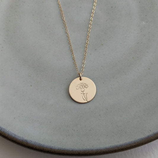 gold disc with carnation flower january birthflower