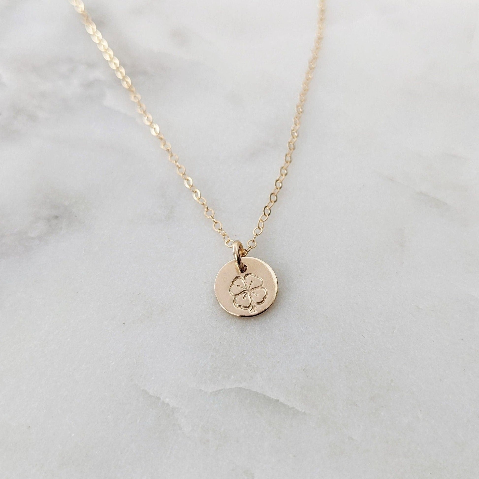 tiny gold filled disc with four leaf clover design
