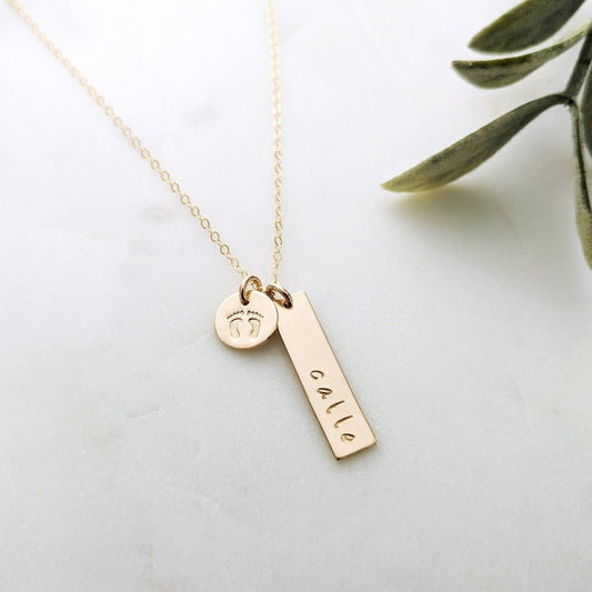 necklace with gold bar personalized with name and small disc with baby footprint design